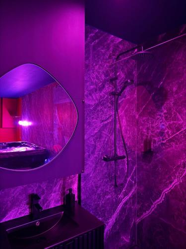 La salle de bains pourpre est pourvue d'une douche et d'un miroir. dans l'établissement 50 Nuances de Plaisir, à Anstaing
