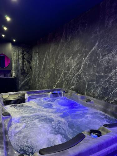 - une baignoire jacuzzi avec eau bleue dans la chambre dans l'établissement 50 Nuances de Plaisir, à Anstaing