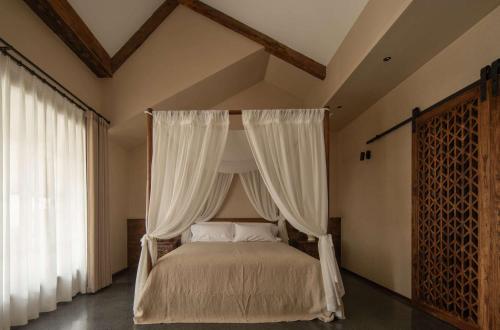 a bedroom with a canopy bed with white curtains at YueLore Retreat in Ta-mien-chen