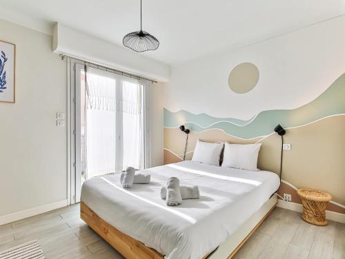 une chambre avec un grand lit et une grande fenêtre dans l'établissement Appartement cocooning proche centre ville et gare, à Les Sables-dʼOlonne