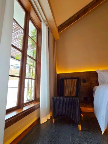a bedroom with a bed and a window and a chair at YueLore Retreat in Ta-mien-chen