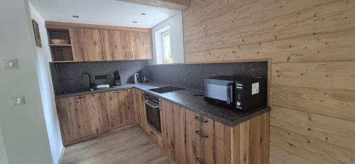 a kitchen with wooden cabinets and a microwave on a counter at Pension Zillnhäusl in Schönau am Königssee
