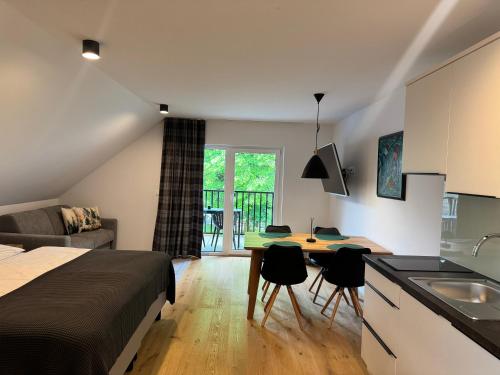 克拉尼斯卡戈拉Apartmaji Kotnik的一间带床的卧室和一间带桌子的厨房