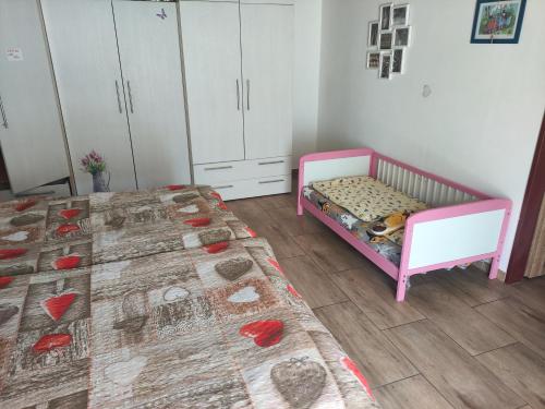 a bedroom with a bed and a crib and cabinets at Ubytování Okřínek ONE in Okřínek