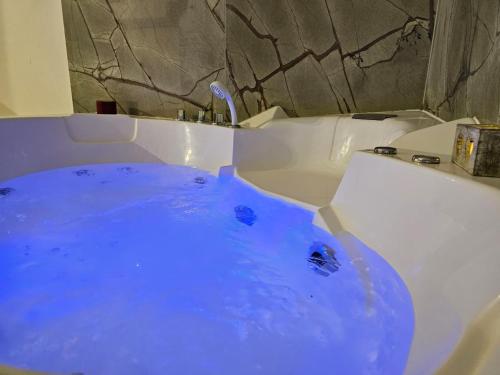 a tub filled with blue water in a bathroom at Florence Colonna Spa in Florence