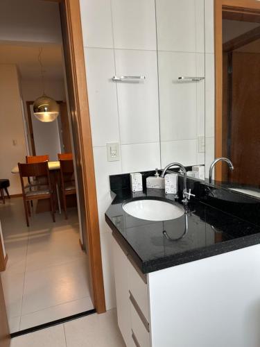un bagno con lavandino e specchio di Piscina,sauna ,ar condicionado a 30passos da Bacutia a Guarapari