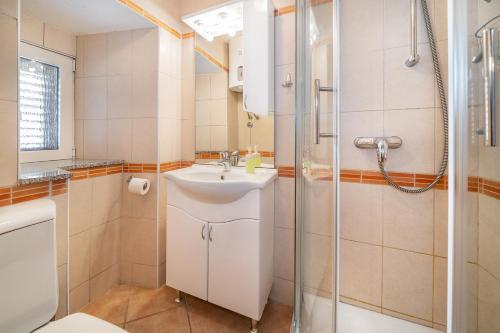 een badkamer met wastafel en douche bij Studio Apartment Tea in Baška