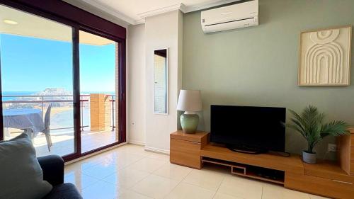 a living room with a flat screen tv on a wooden cabinet at Blaucel apartment in Peñíscola