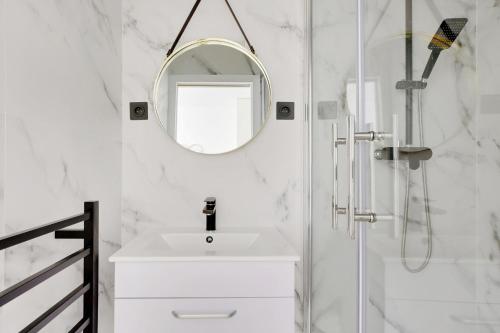une salle de bain blanche avec un lavabo et un miroir dans l'établissement Pick A Flat's Apartment in Tour Eiffel - Rue du Champs de Mars, à Paris