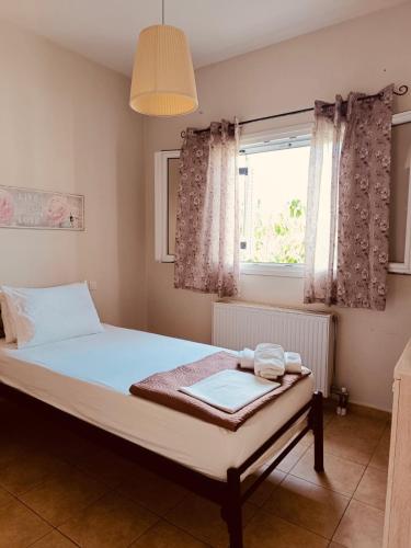 a bedroom with a large bed with a window at Rosa Viola in Corfu