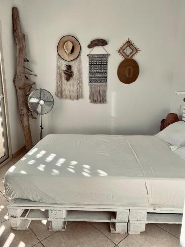 - un lit dans une chambre avec des chapeaux au mur dans l'établissement Corsica Sant Ambroggio House of Blanche, à Lumio