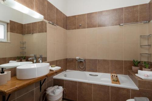 a bathroom with a large tub and two sinks at Pithos Apartment in Korakiaí