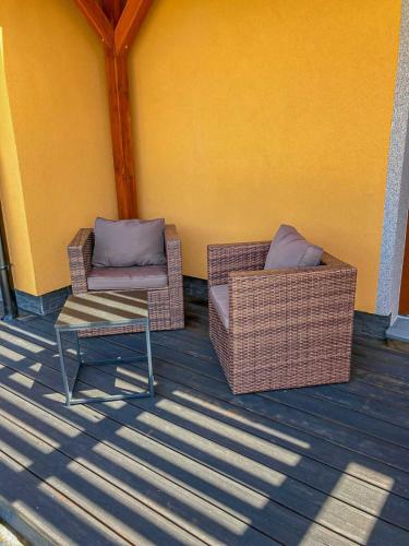 two wicker chairs and a table on a porch at Apartmány Na Vyhlídce - Wellness in Horní Planá