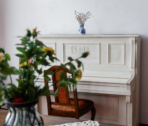 a table with a chair and a vase with a plant at Hotel Traube in Mediaş
