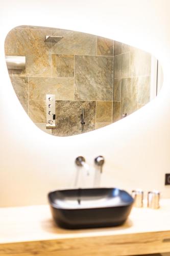 a bathroom with a black sink and a mirror at La Sainthilarienne in Saint-Lary-Soulan