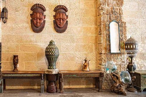a wall with a bench and masks on a wall at Casa- event home in Jaffa in Tel Aviv