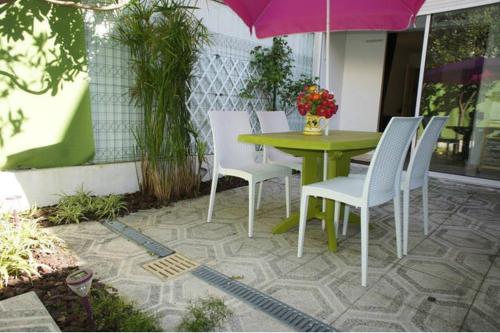 un patio avec une table, des chaises et un parasol dans l'établissement CANNES POINTE CROISETTE Garden & Beach, à Cannes