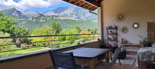 a balcony with a table and a view of mountains at Chambre d'hôte de Reymure in Vif