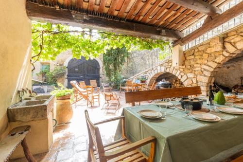 une table avec un tissu de table vert sur une terrasse dans l'établissement Le Lion d'Or, à Lagorce