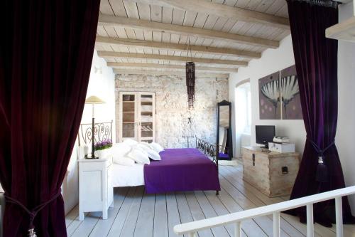 a bedroom with a bed with a purple blanket at Casa Degrassi - Main square - Seaview in Vrsar