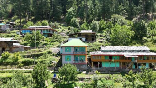 a group of houses on a hill with trees at Aurelia by Xtastays - Deohari, Sainj Valley, Kullu in Sainj