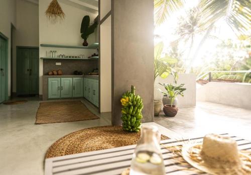a kitchen with a table with a bunch of bananas at Water's Edge Villa in Ahangama