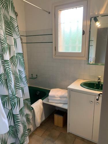 une salle de bain avec un lavabo et un rideau de douche dans l'établissement Villa la Roche Cannes, Meerblick, Salzwasserpool, Sauna, à Mandelieu-la-Napoule