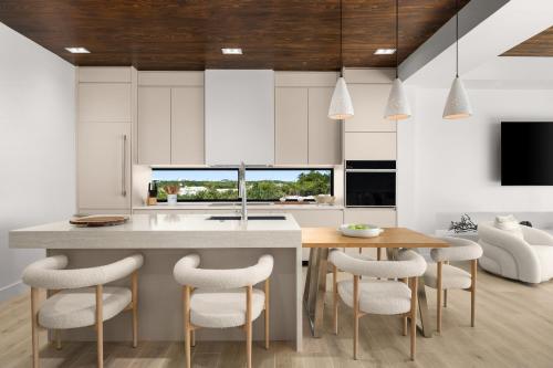 a kitchen with white cabinets and a table and chairs at Villa Angelina in Leeward