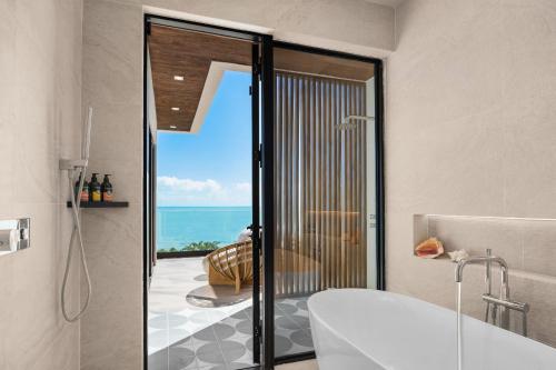 a bathroom with a tub and a view of the ocean at Villa Angelina in Leeward