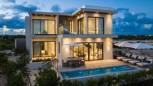a house with a swimming pool in front of it at Villa Angelina in Leeward