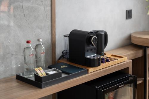 a coffee machine sitting on a wooden counter with bottles at Kin Hotel Thai Van Lung in Ho Chi Minh City