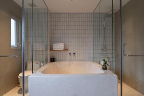 a large bath tub in a bathroom with a toilet at Kin Hotel Thai Van Lung in Ho Chi Minh City