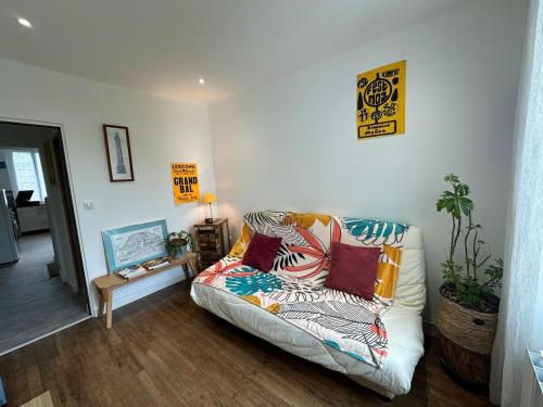 - un salon avec un canapé et des oreillers dans l'établissement Maison Années 30 - Terrasse - Parking gratuit - Proche CV, à Quimper