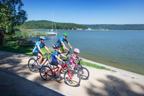 a group of people riding bikes next to the water at Hotel Port Doksy in Staré Splavy