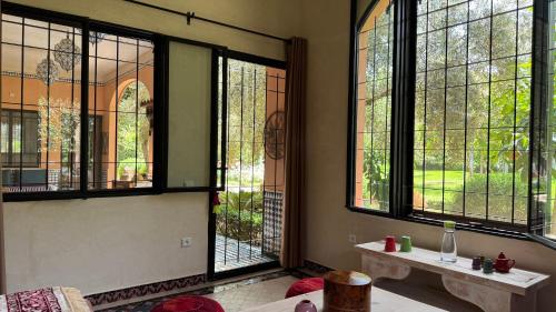 a room with large windows in a home with at Suite - Dar Tidyan Maison d'Hôtes - Ourika Valley in Igzi Ou Fella