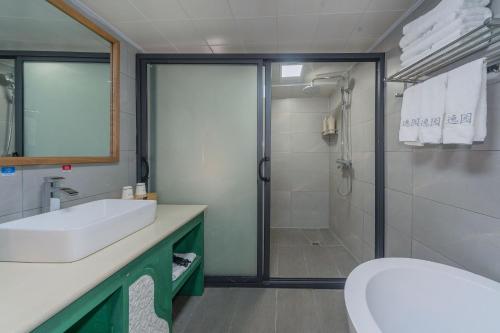 a bathroom with a shower and a sink and a toilet at Yiyuan Snow Mountain View Historical Naxi House - Lijiang Old Town Mufu branch in Lijiang