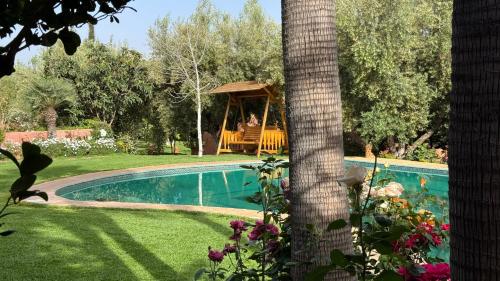 a person sitting in a gazebo next to a pool at Suite - Dar Tidyan Maison d'Hôtes - Ourika Valley in Igzi Ou Fella