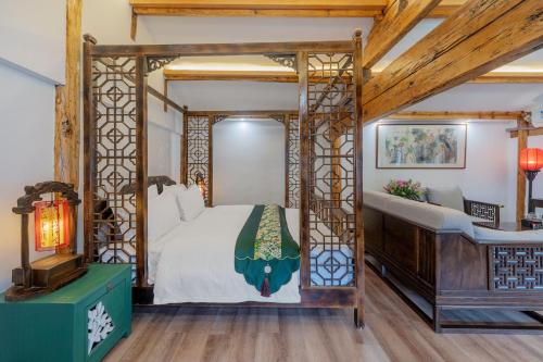 a bedroom with a four poster bed and a piano at Yiyuan Snow Mountain View Historical Naxi House - Lijiang Old Town Mufu branch in Lijiang
