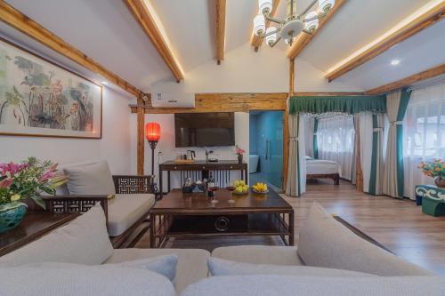 a living room with a couch and a table at Yiyuan Snow Mountain View Historical Naxi House - Lijiang Old Town Mufu branch in Lijiang