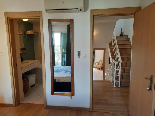 a room with a hallway with a mirror and a staircase at Guesthouse Le Châtelain in Santa Maria