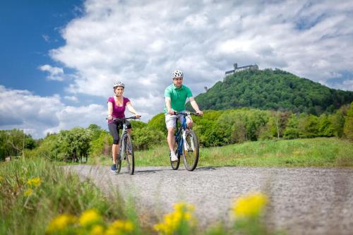 a man and a woman riding bikes down a road at Hotel Port Doksy in Staré Splavy