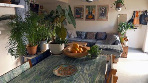 un salon avec une table avec un bol d'oranges dessus dans l'établissement L'Art'Home à Carnon Plage, à Mauguio