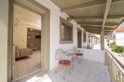a balcony with a table and chairs and a couch at MAKIS VILLAGE-APARTMENTS in Ayia Evfimia
