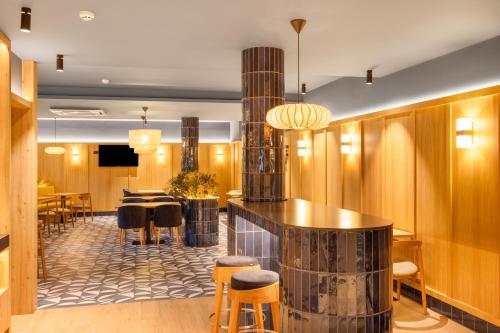 a lobby with a bar with chairs and tables at B&B HOTEL Braga Lamacaes in Braga
