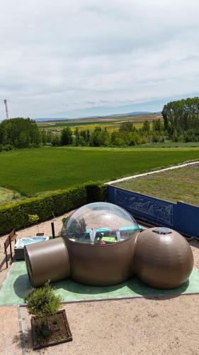 a large object with a glass dome on a field at COSMOVEROS - Hotel Burbuja in Pedraza-Segovia