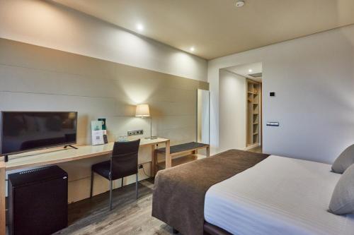 a hotel room with a bed and a desk at Silken Puerta Valencia in Valencia