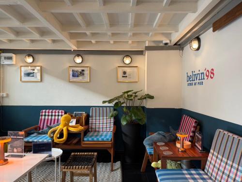 a restaurant with chairs and tables and clocks on the wall at Belivin'98 Sense of Pier Sathorn Residence in Bangkok