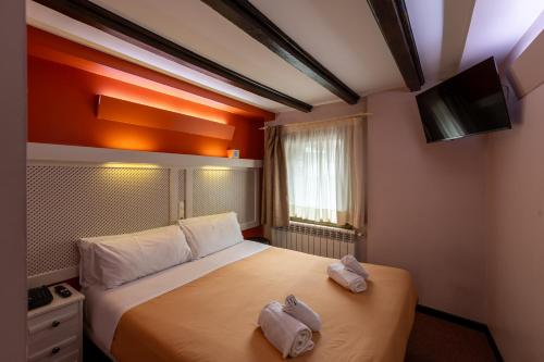 a hotel room with a bed with two towels on it at Hotel Micolau in Arinsal