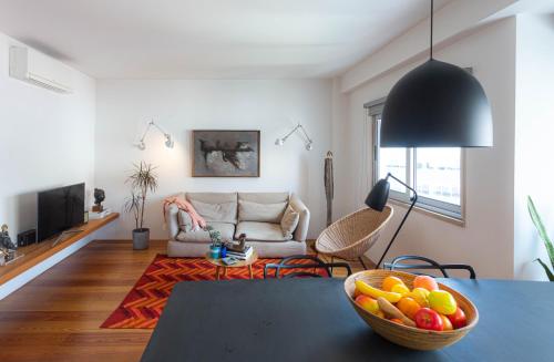 a living room with a table with a bowl of fruit at Design in Liberdade - 2 bedroom Apartment, Marquês Pombal in Lisbon