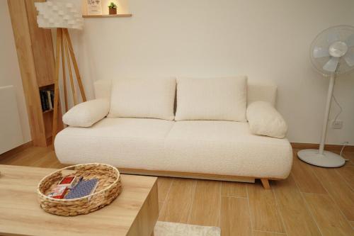 a living room with a white couch and a basket at La Bulle Chic, Netflix - central in Montargis